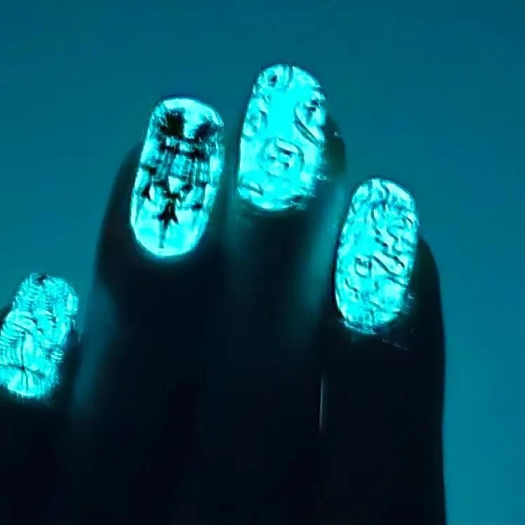 Glow polish shown on nails under low-light conditions.
