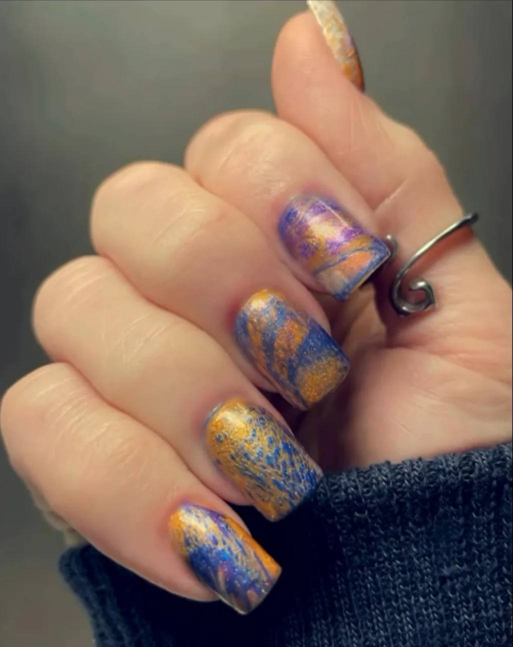 Metallic blue, purple, and gold effect photographed in customer or creator use.