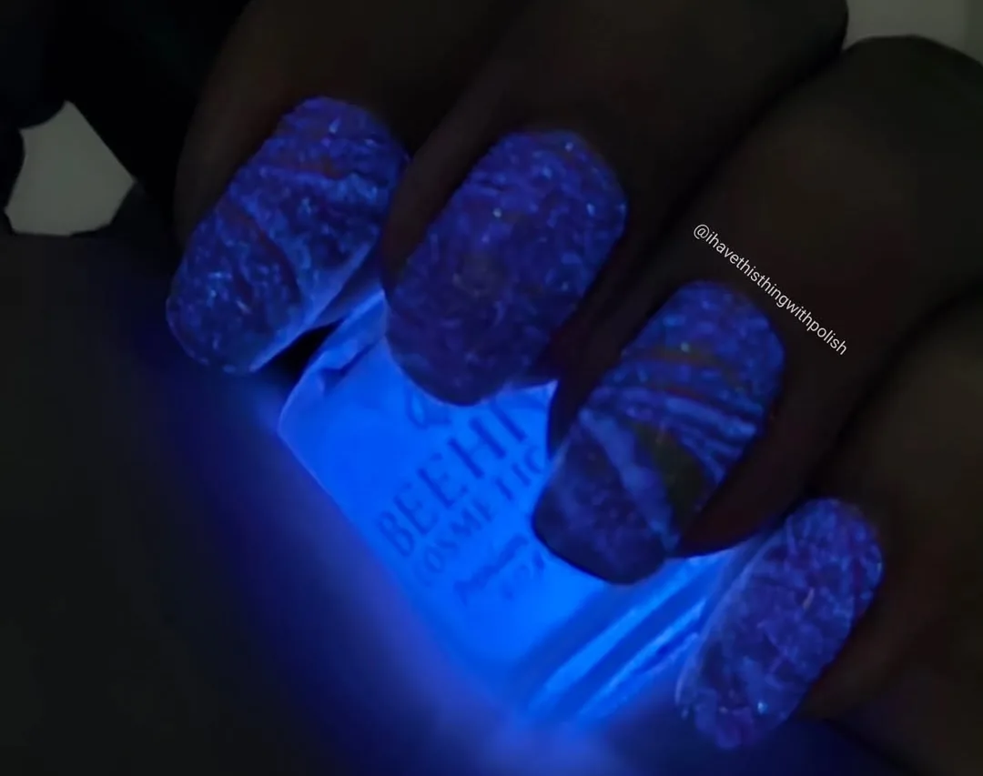 Blue UV-reactive nail effect with creator attribution preserved.