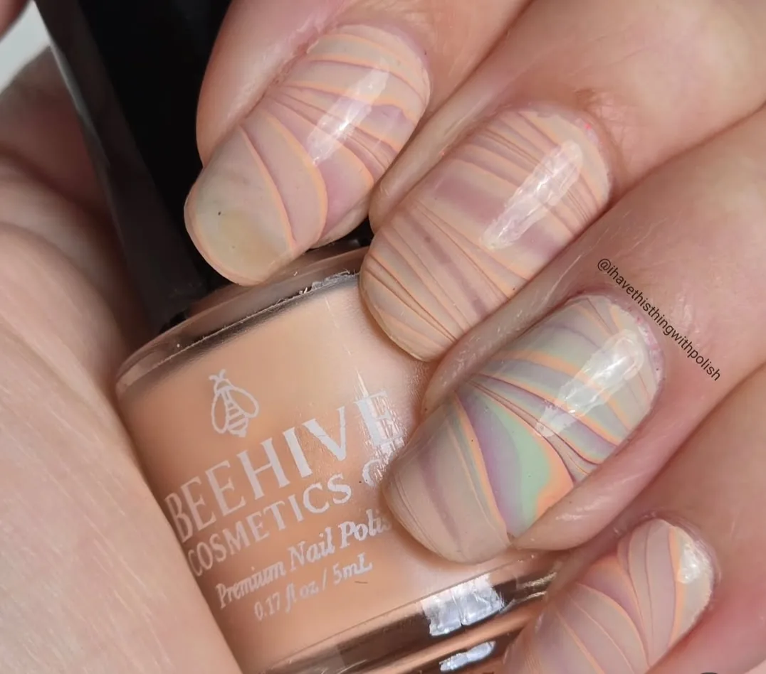 Neutral marbling effect using layered polish lines; creator attribution remains visible.