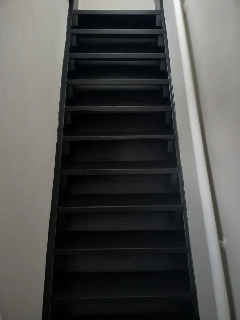 Stairway after refinishing with a uniform dark finish.